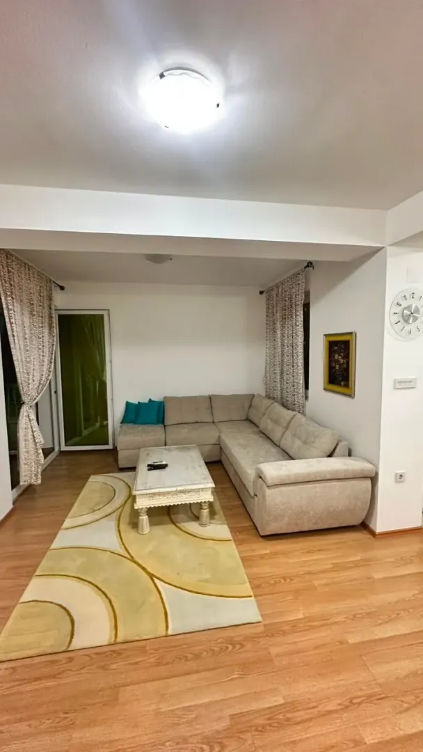 Living room with a sectional sofa, coffee table, and parquet flooring.
