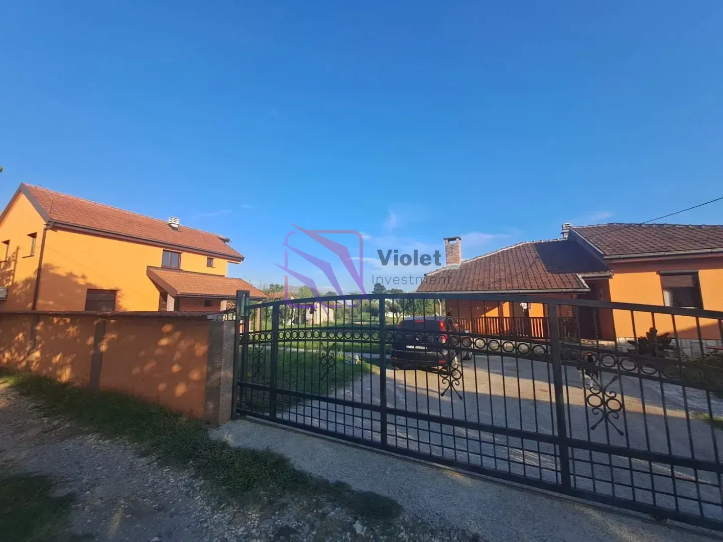 Pogled na dvorište i spoljašnjost kuće sa ulaznom kapijom.