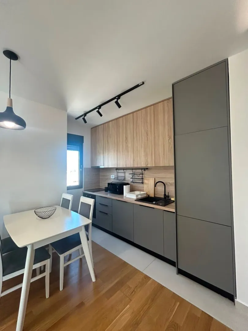 Modern kitchen with a dining table and grey cabinets.