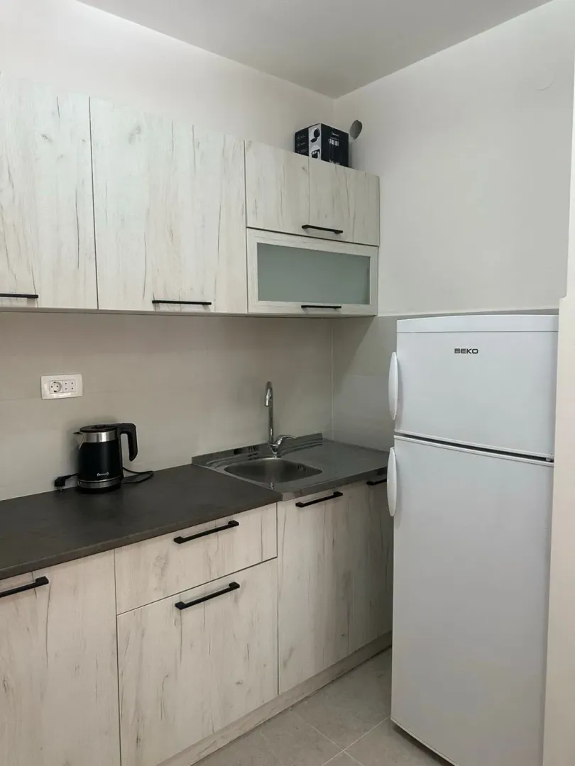 Small kitchen with light-colored cabinets and a white refrigerator.