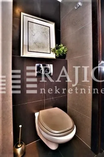 Modernly equipped bathroom with dark tiles and built-in fixtures.