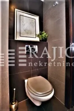 Modernly equipped bathroom with dark tiles and built-in fixtures. - image 10