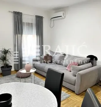 Bright living room with a sofa and dining table. - image 2