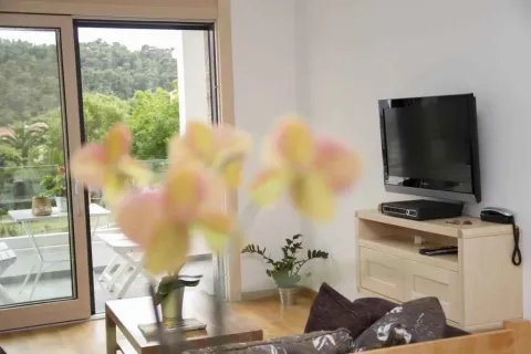 Svijetla dnevna soba sa televizorom i izlazom na terasu. - image 5