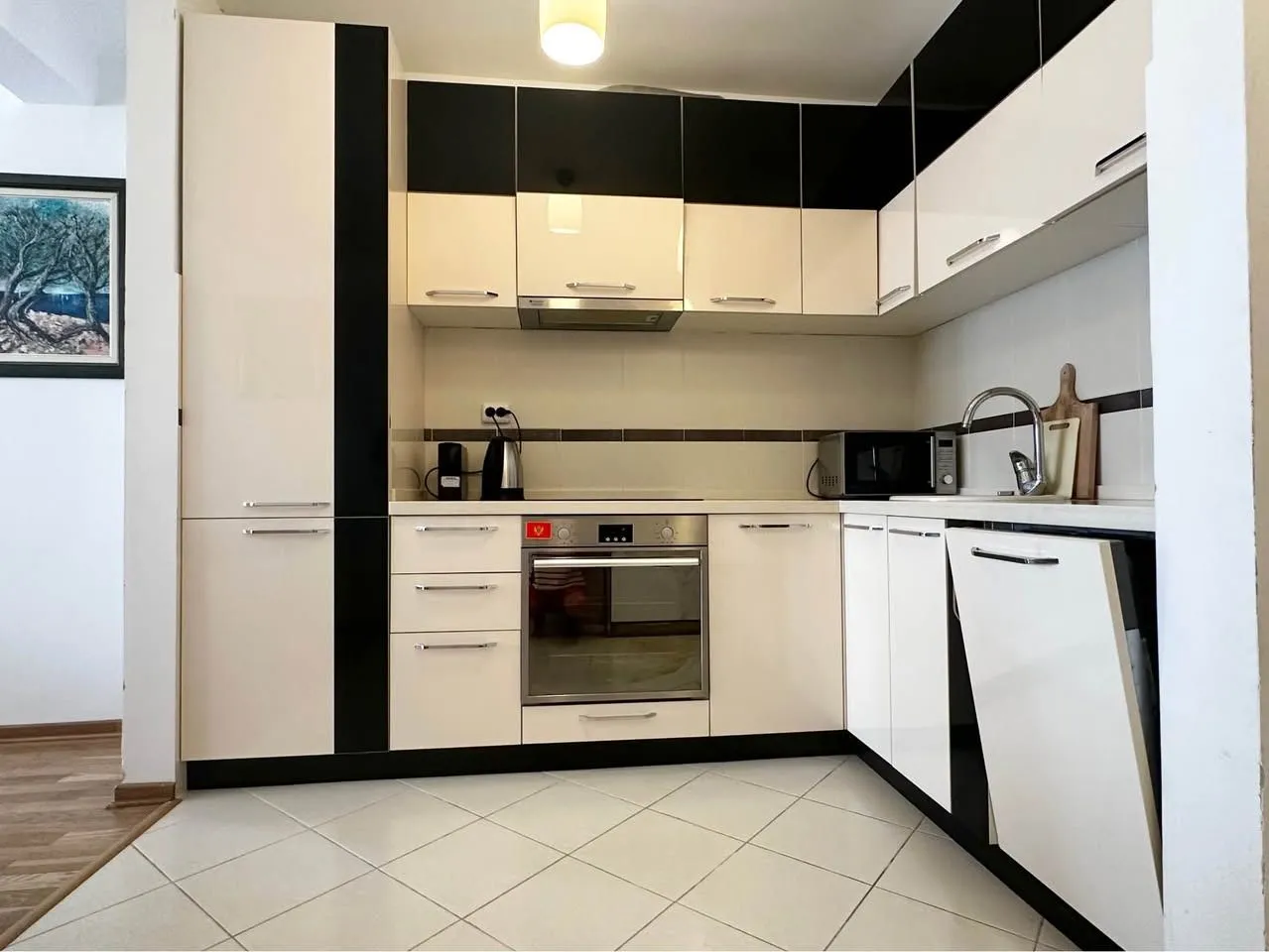 Kitchen equipped with white and black cabinets and built-in appliances.