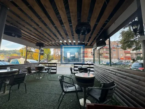 Covered terrace with wooden structure and barrel-shaped tables. - image 12