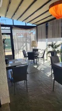 Enclosed terrace with seating furniture and a view of the outdoor area. - image 2