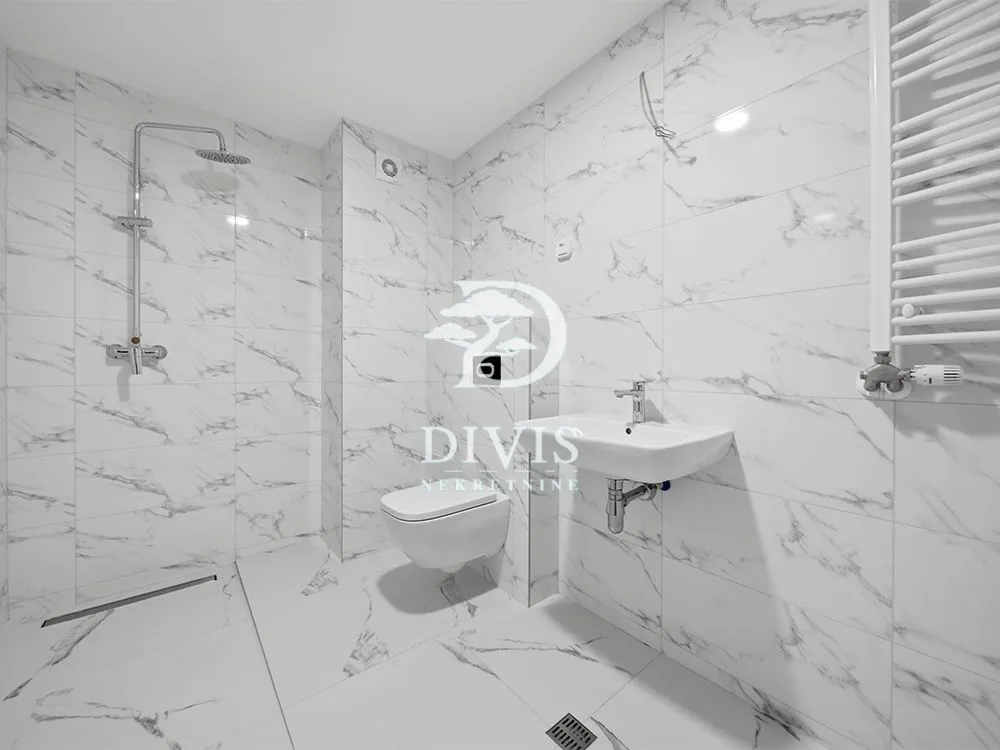 Modern bathroom with marble tiles, a walk-in shower, and a wall-hung toilet.
