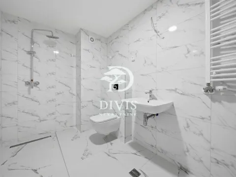 Modern bathroom with marble tiles, a walk-in shower, and a wall-hung toilet. - image 6