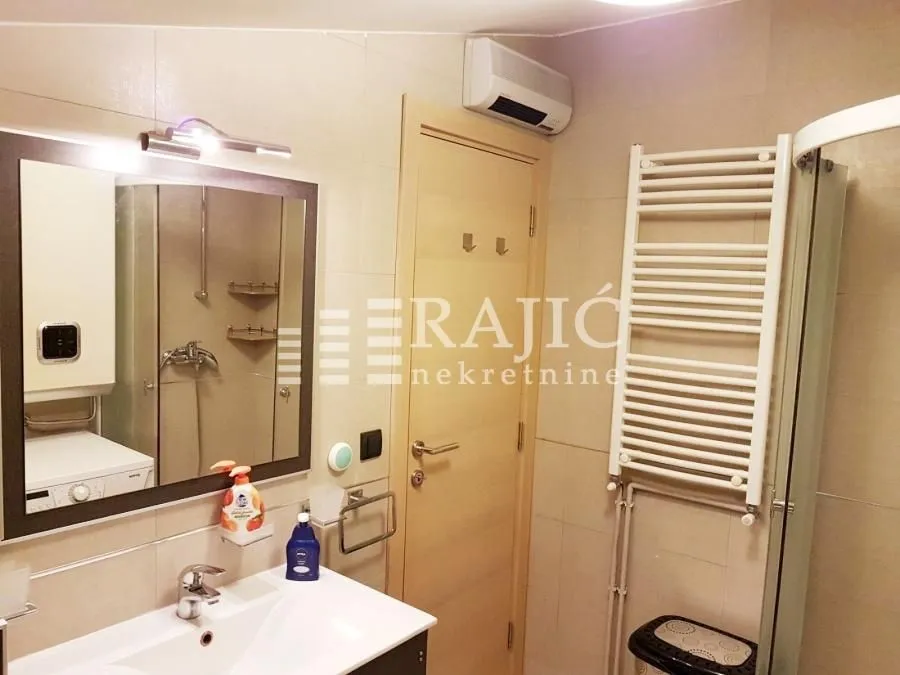 Furnished bathroom with a sink, mirror, and shower cabin.