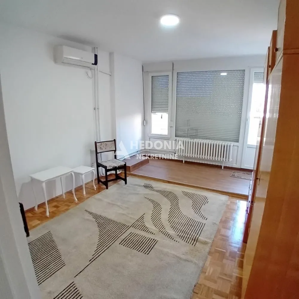 Living room with parquet flooring, rug and access to the terrace.