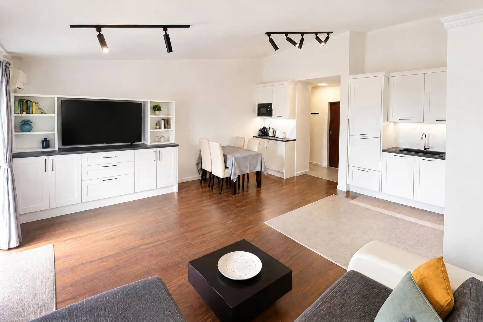 Spacious living room with a dining area and kitchen in light tones.