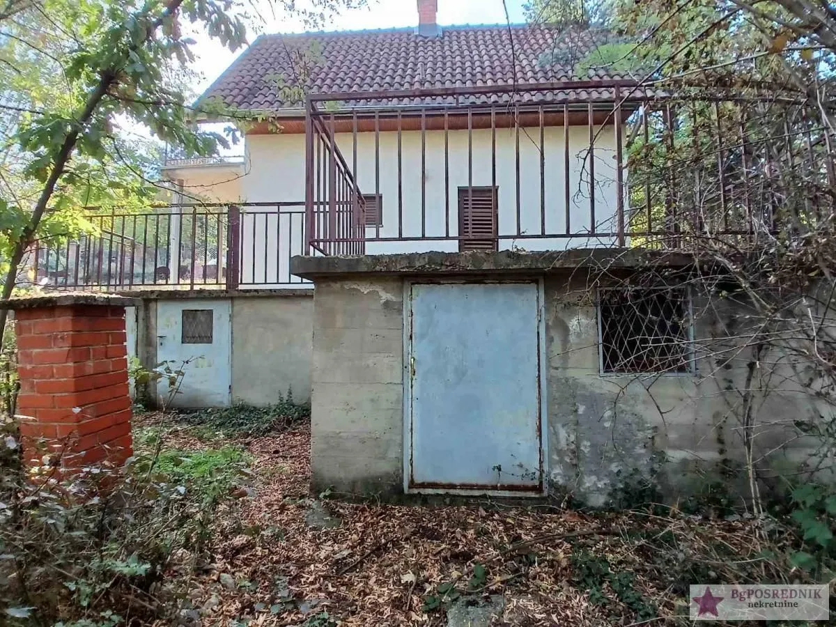 Pogled na spoljašnjost kuće sa terasom i dvorištem.