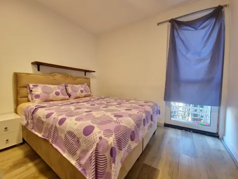 Spavaća soba sa bračnim krevetom i prozorom koji gleda spolja. - image 5