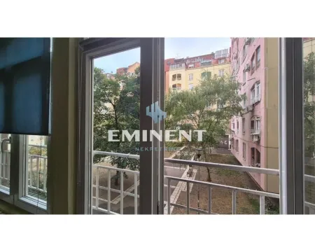 View through the window of surrounding buildings and a courtyard full of greenery. - image 12
