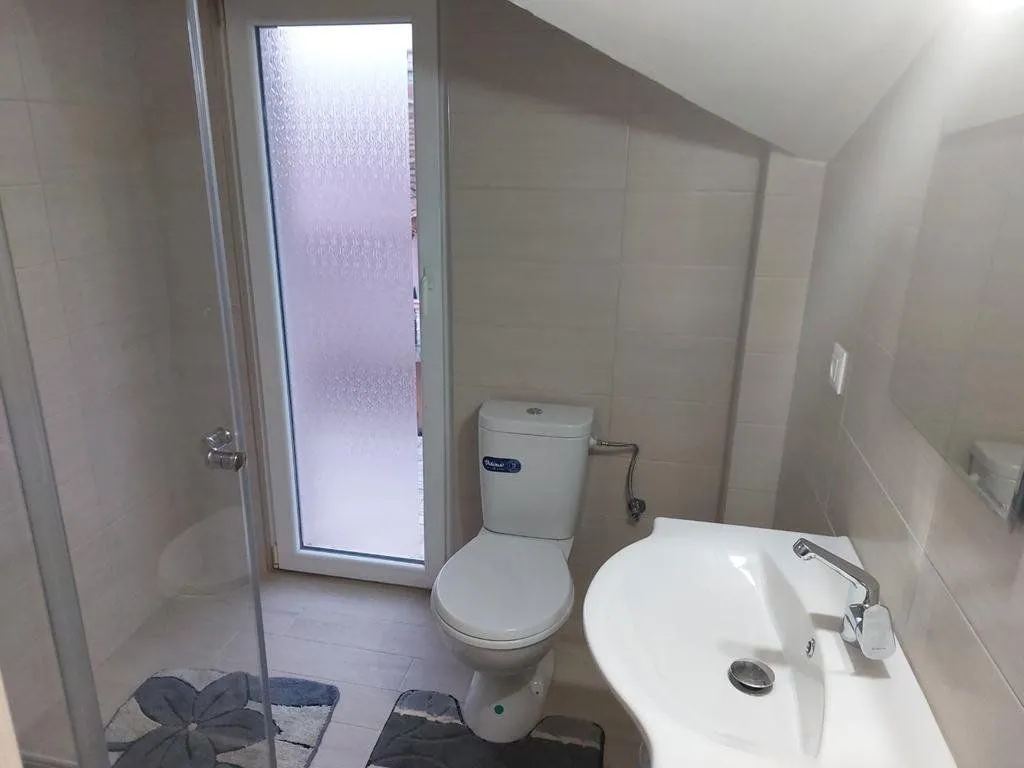 Bathroom equipped with sanitary fixtures, a shower cabin, and a door leading to the terrace.