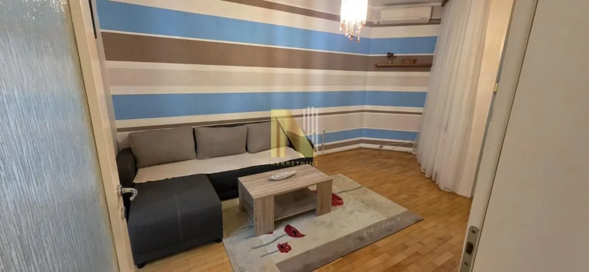 Dnevna soba sa ugaonom garniturom i stočićem.