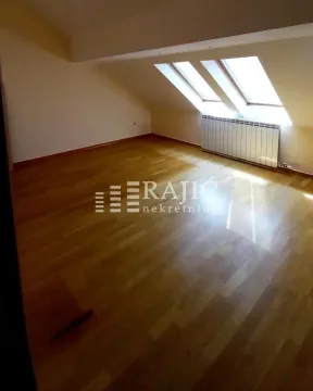 Empty attic room with wooden flooring and roof windows. - image 6