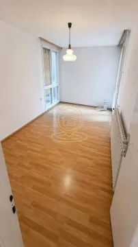 Prazna soba sa laminatom i belim zidovima. - image 3