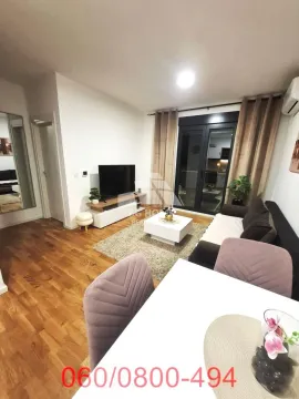 Dnevni boravak sa garniturom, TV komodom i trpezarijskim stolom u prvom planu. - image 4