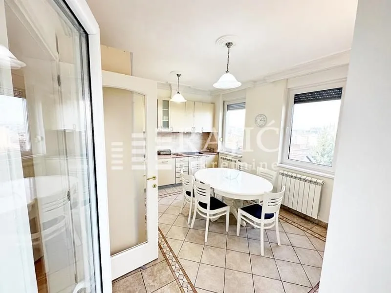 Dining area connected to the kitchen with a white table and chairs.