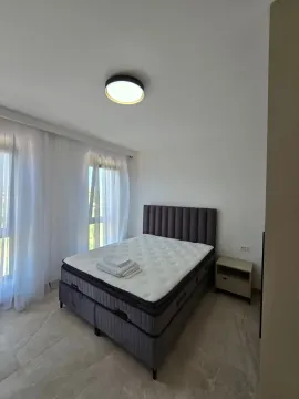 Spavaća soba sa bračnim krevetom, noćnim ormarićem i velikim prozorima sa bijelim zavjesama. - image 5