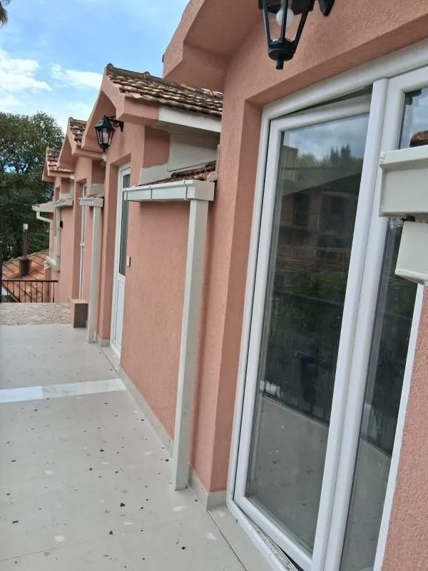 Pogled na spoljašnji dio objekta sa terasom i ulaznim vratima.