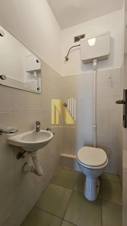 Manje kupatilo sa lavaboom, wc šoljom i zidnim ogledalom.