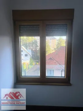 Pogled kroz prozor na okolne kuće i zelenilo. - image 24