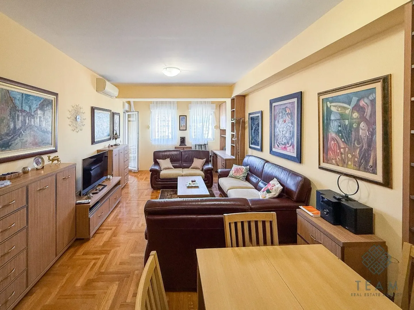 Spacious living room with seating furniture and a dining table.