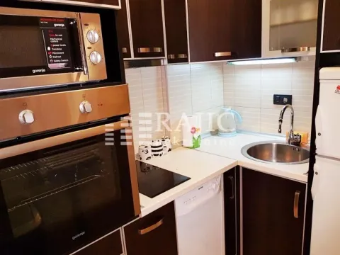 Smaller kitchen with dark cabinets and built-in appliances. - image 4