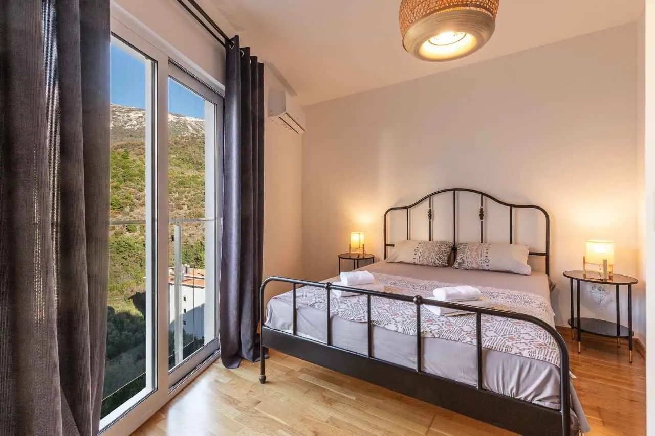 Furnished bedroom with a double bed, bedside tables, and access to the terrace.