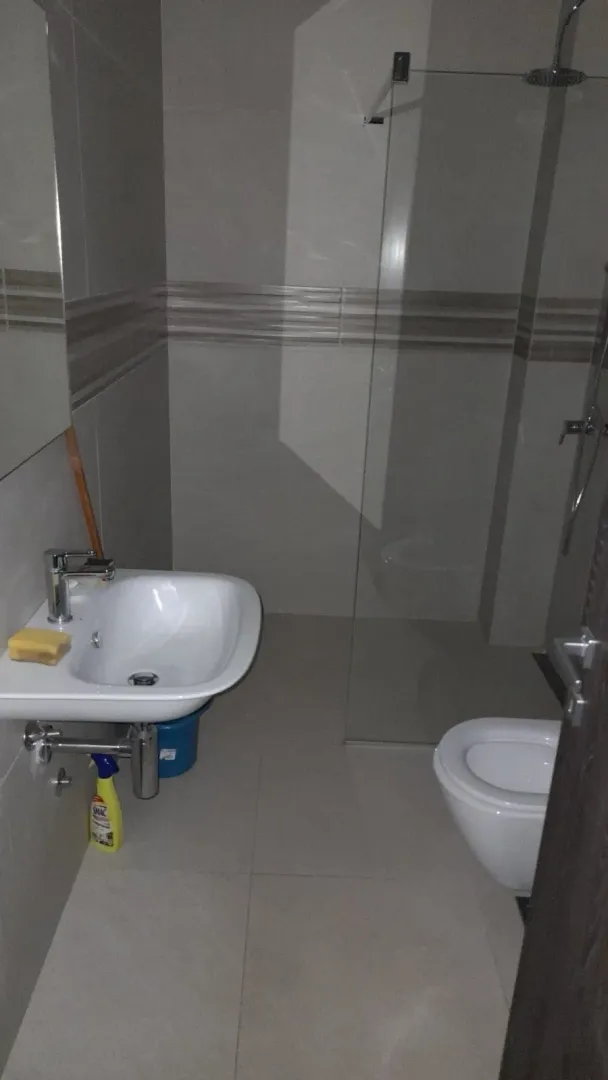 Moderne opremljeno kupatilo sa tuš kabinom i umivaonikom.