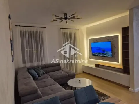 Modern living room with a sectional sofa and wall-mounted TV. - image 3