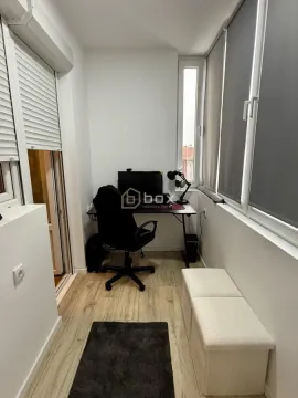 Zastakljena terasa opremljena kao radni prostor sa stolom i stolicom. - image 18