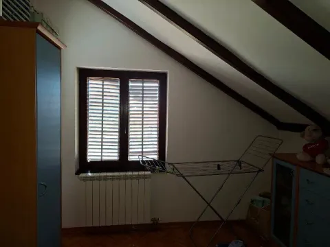 Potkrovlje sa kosim plafonom, drvenim gredama, prozorom i nameštajem. - image 19
