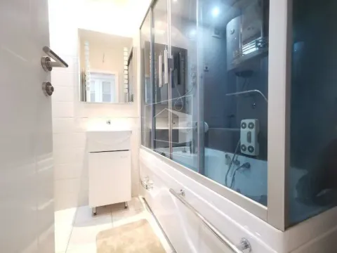 Bathroom with a shower cabin, washbasin, and mirror. - image 7