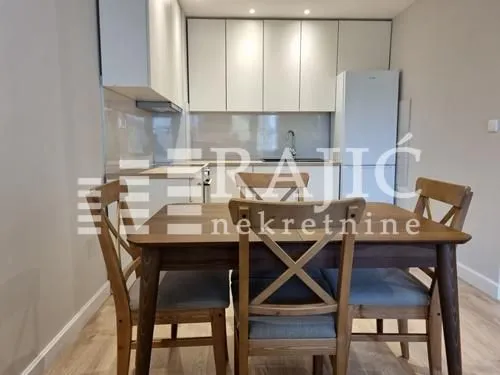 Dining area with a wooden table and chairs, connected to the kitchen.