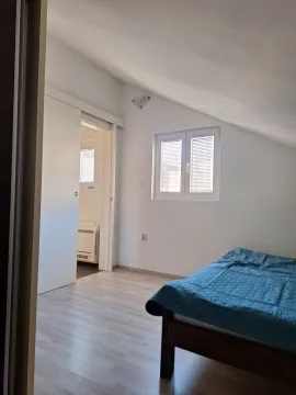 Svijetla spavaća soba sa krevetom i kosim plafonom. - image 7