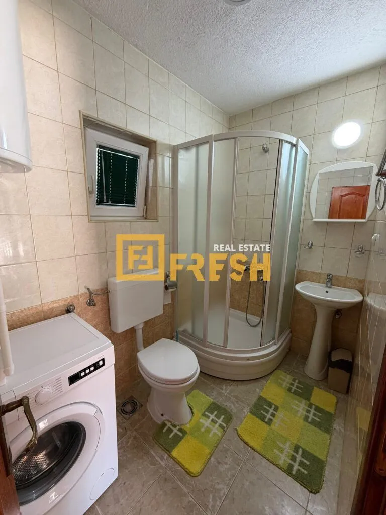Kupatilo opremljeno tuš kabinom, umivaonikom, wc šoljom i veš mašinom.