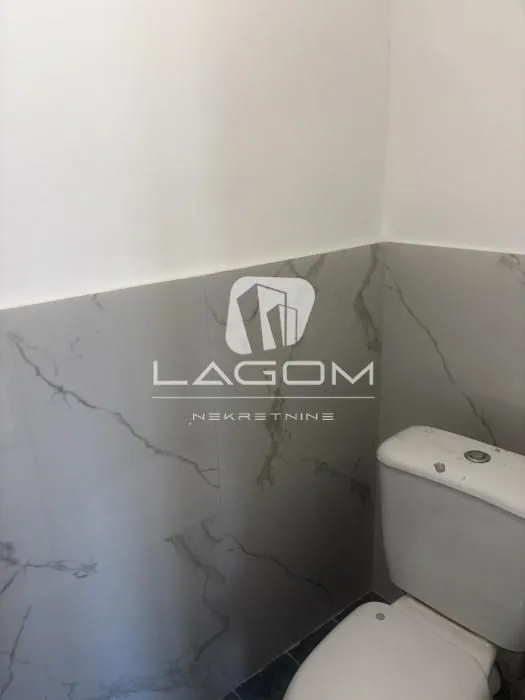 Pogled na deo kupatila sa sanitarijama i zidnim pločicama.