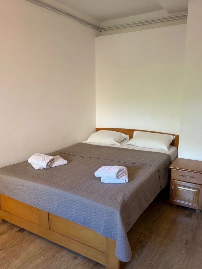 Furnished bedroom with a double bed and a bedside table.