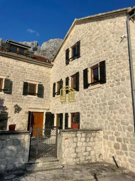 Fasada tradicionalne kamene kuće sa tamnim prozorima i vratima. - image 20
