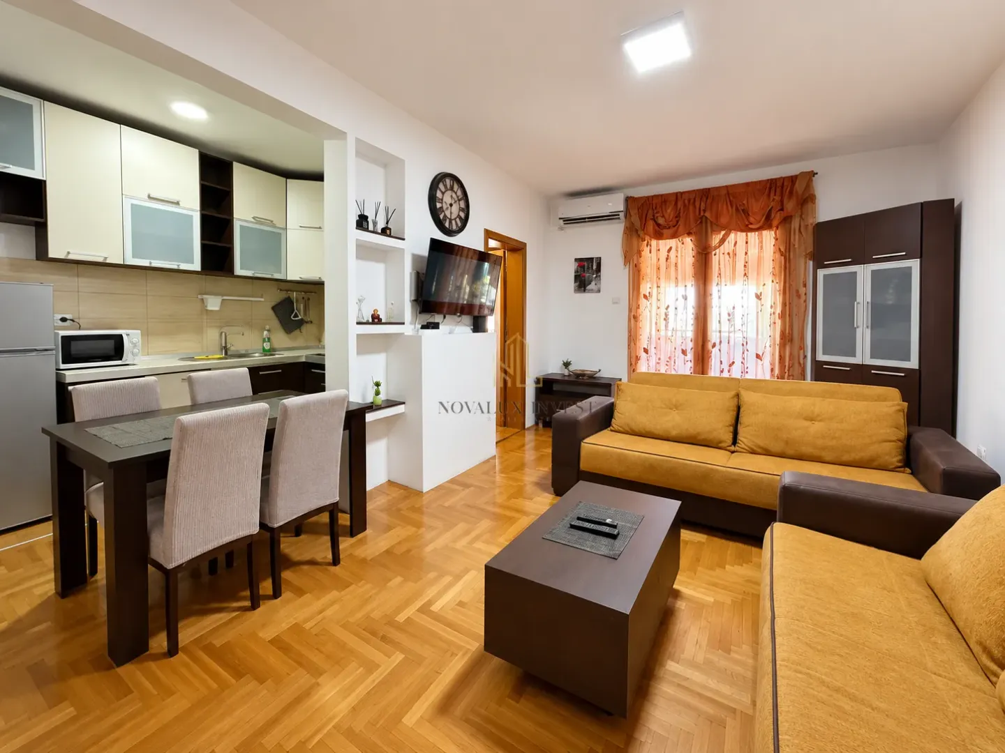 Spacious living room with sofa set, dining area, and open kitchen.