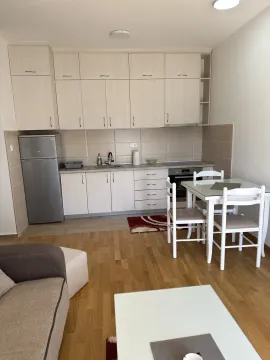Kitchen with a dining table and light-colored cabinets. - image 12