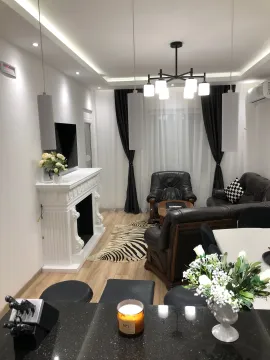 Modern living room with a fireplace, sofa set, and dining area. - image 17