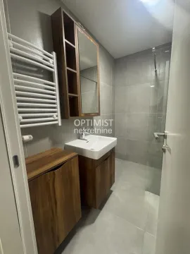 Savremeno opremljeno kupatilo sa tuš kabinom i drvenim elementima. - image 8