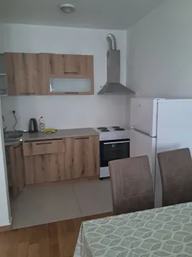 Manja kuhinja sa drvenim elementima i trpezarijskim stolom. - image 3