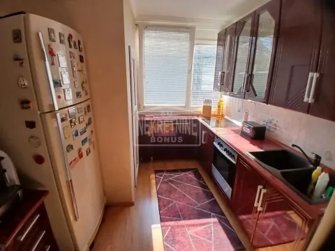 Manja kuhinja sa tamnim drvenim elementima i belim frižiderom. - image 6