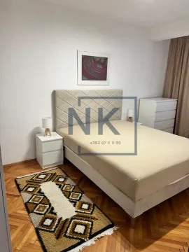 Furnished bedroom with a double bed, bedside tables, and parquet flooring. - image 7
